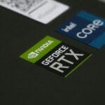 Close-up of NVIDIA GeForce RTX and Intel Core i7 stickers on a laptop surface, showcasing modern technology.